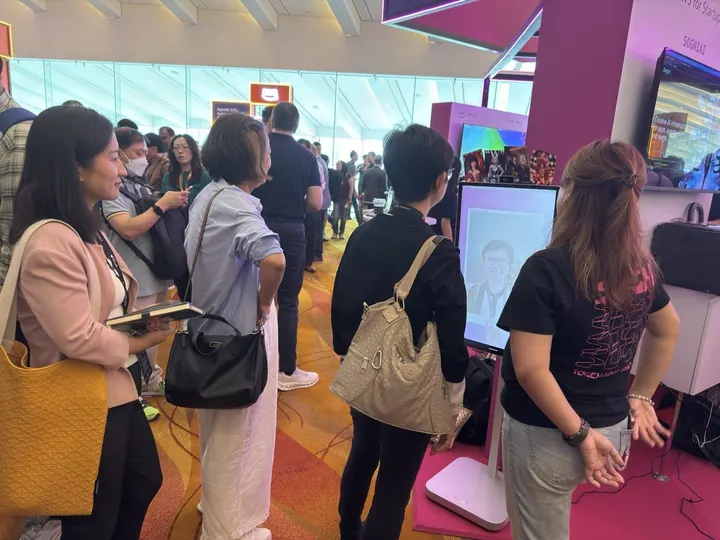 Guests queue at the AI photobooth at a conference in Singapore
