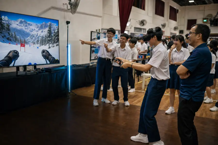 Students in a school hall watch a classmate play a VR game at a STEM day